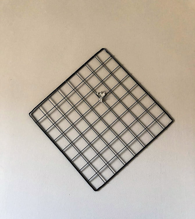 Wire grid square hanging on the wall.