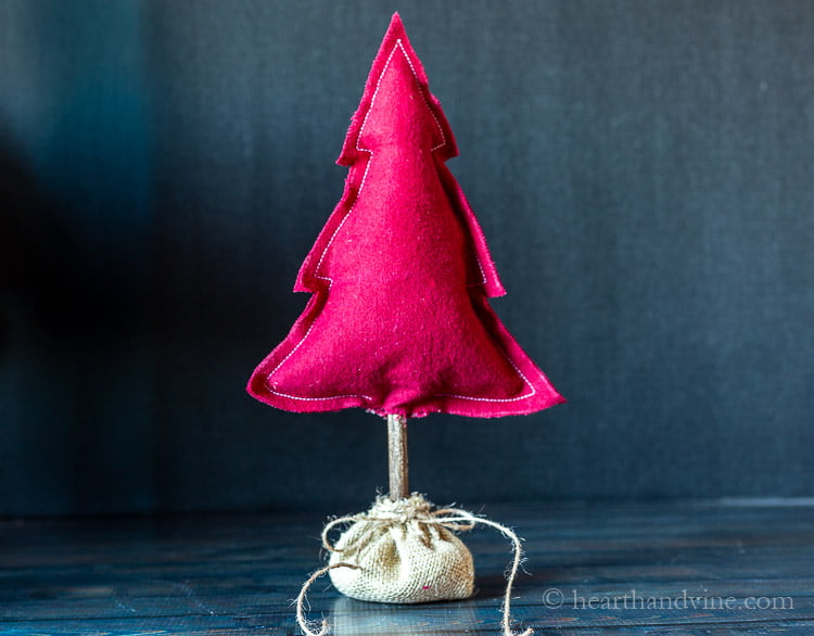 Fabric stuffed Christmas tree in dark red flannel on a table.