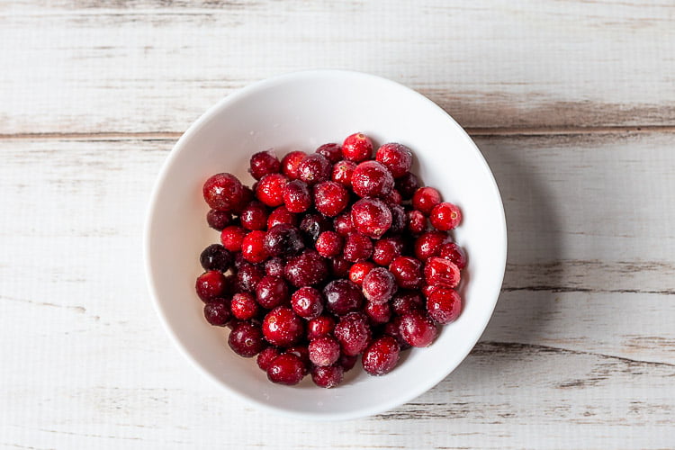 White bowl of sugared cranberries.
