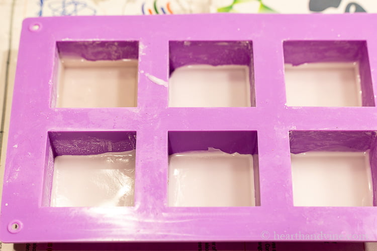 Six cell square soap mold with a small amount of beeswax in each cell.