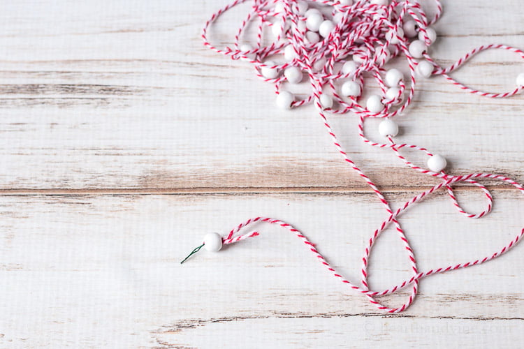 Red and white twin with white beads strung and 3-4 inch intervals.