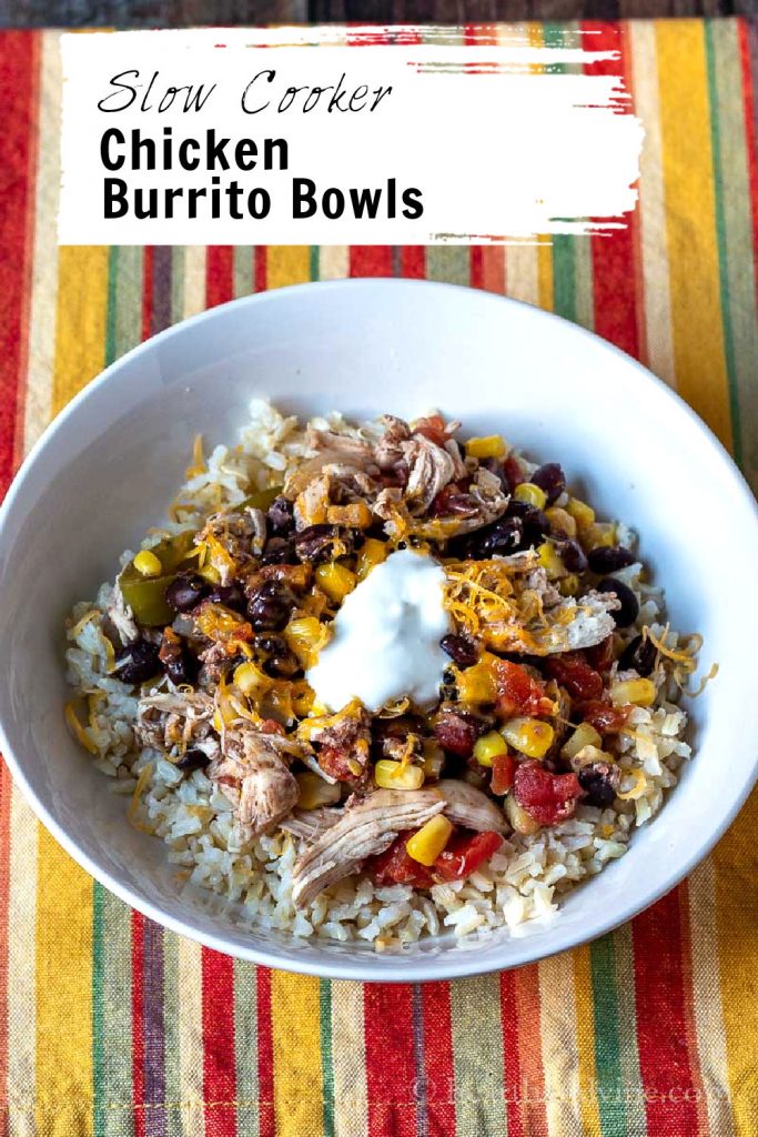 White bowl with chicken burrito mix on top of brown rice.