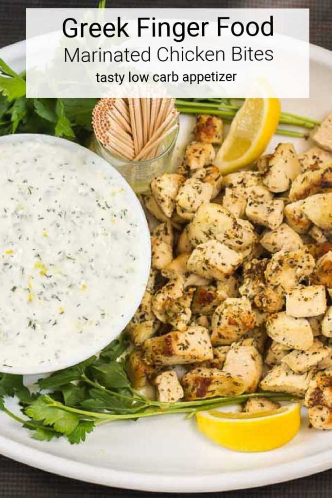 Marinated chicken breast bites on a platter with a bowl of Tzatziki sauce.