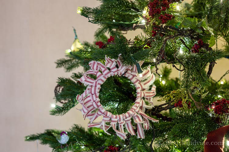 Red and white striped fabric ornament hanging on the Christmas tree.