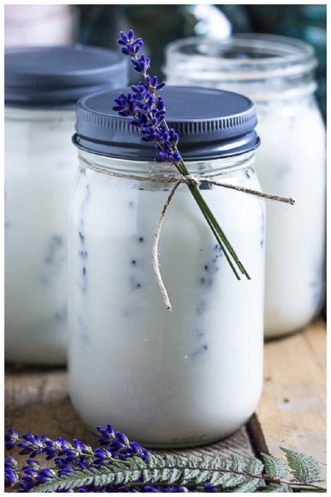 Mason jar candle with lavender flowers on sides.