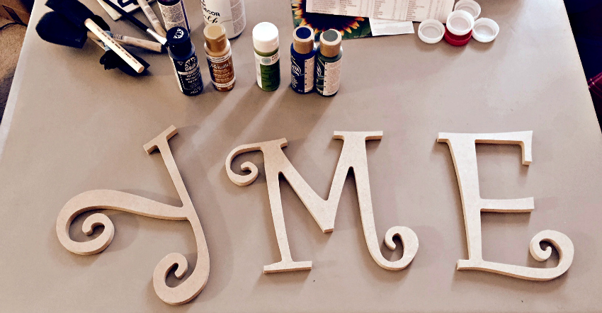 Three wood letters. Capital Y, M and E.