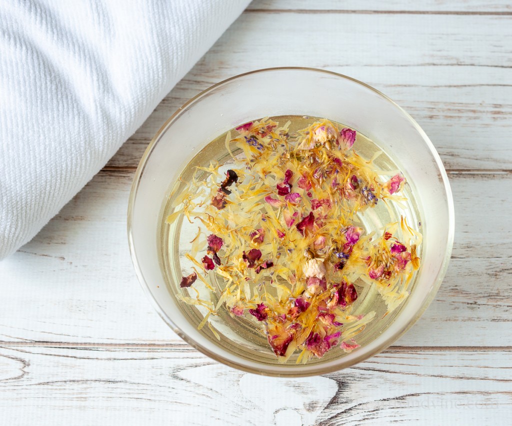 Bowl of water with dried herbs for face steaming.