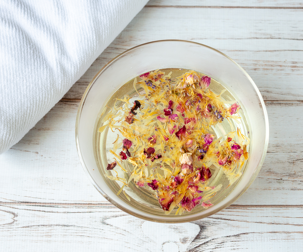 bowl of water with herbs and a white towel