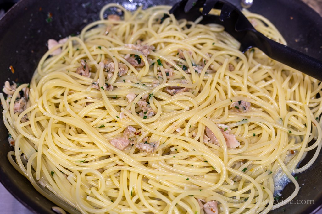 A large pan of spaghetti with white clam sauce.