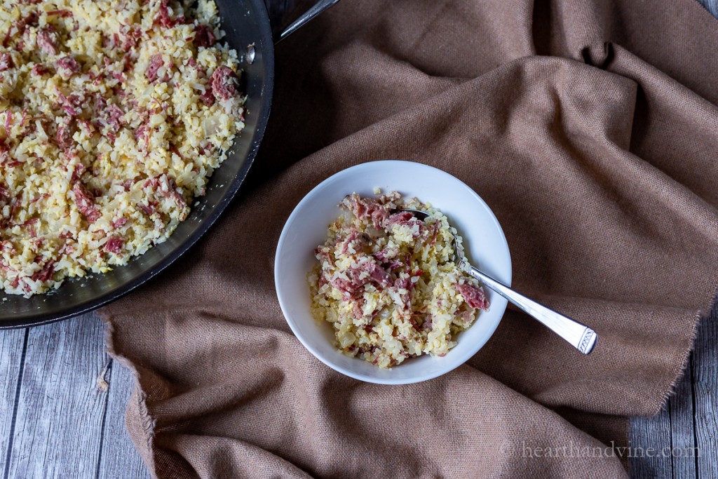 Bowl of low carb corned beef hash with eggs and cauliflower rice.