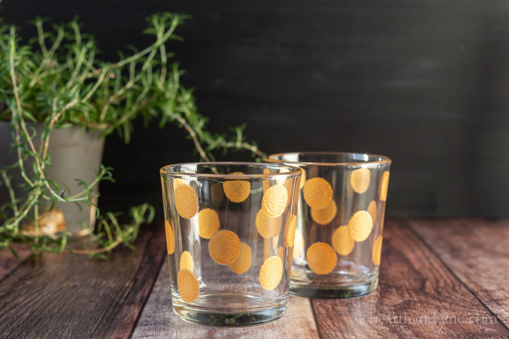 Whiskey rocks barware with gold dots painted on them.