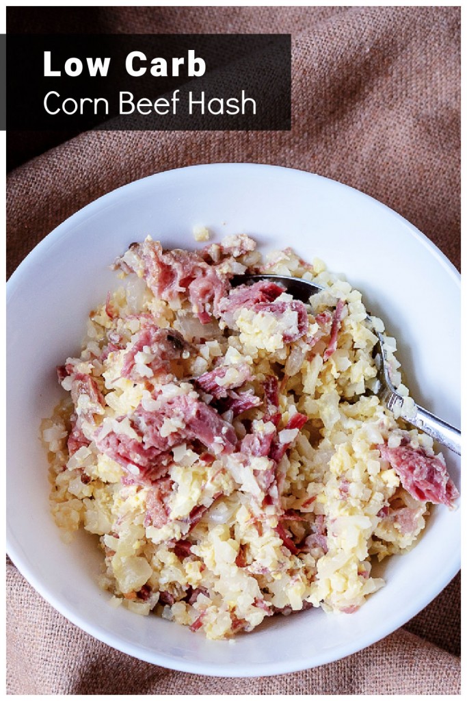 White bowl with a spoon containing low carb corned beef hash with eggs and cauliflower rice.