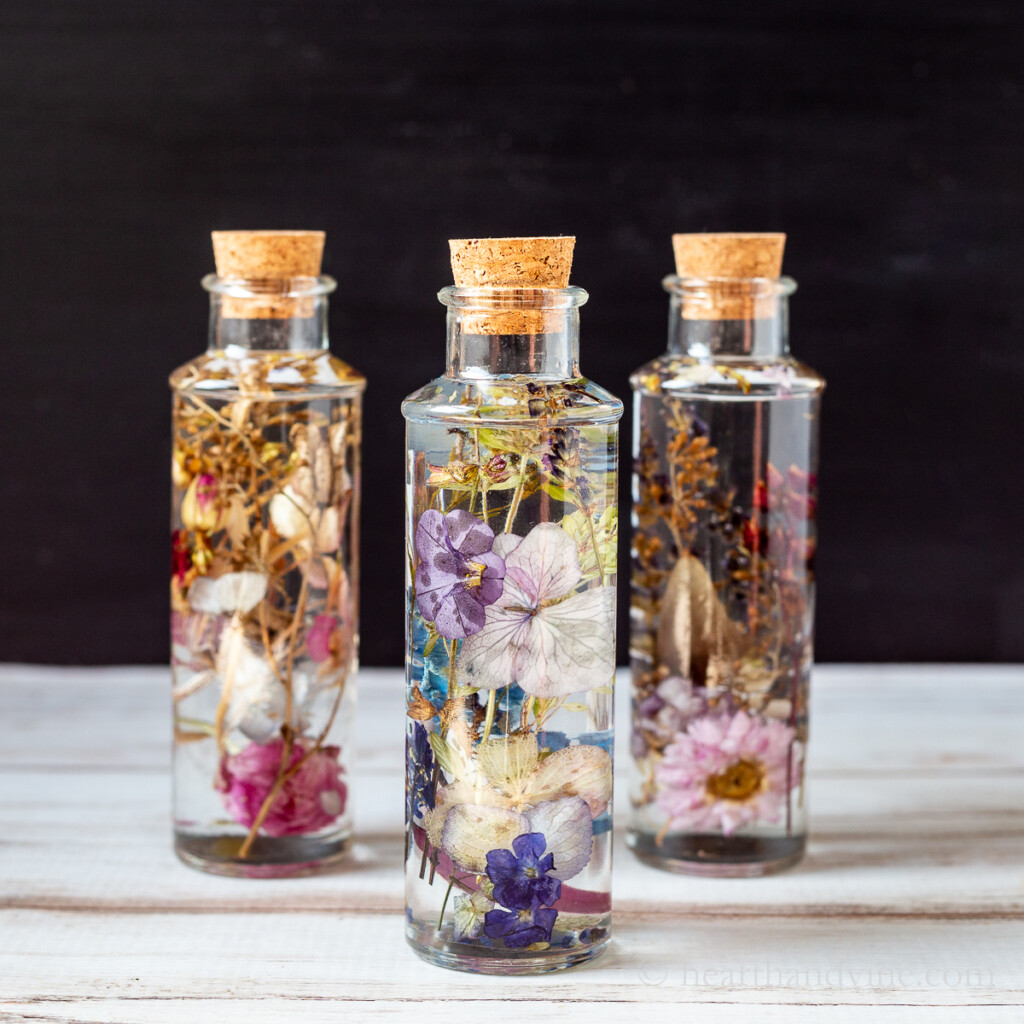 Three dried flowers in oil bottles.