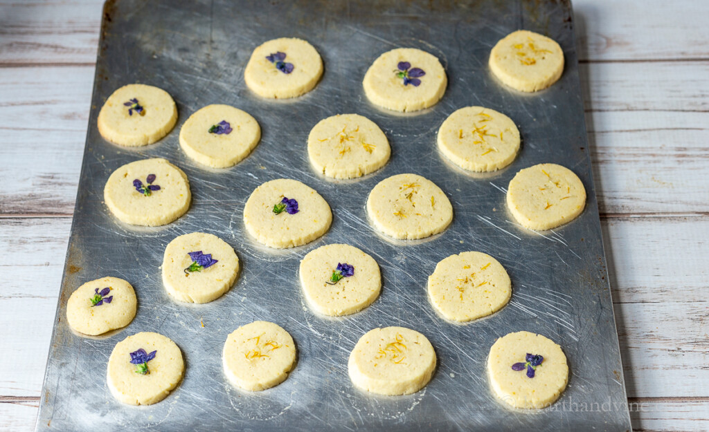 Baking sheet of violet flower and dandelion cookies.