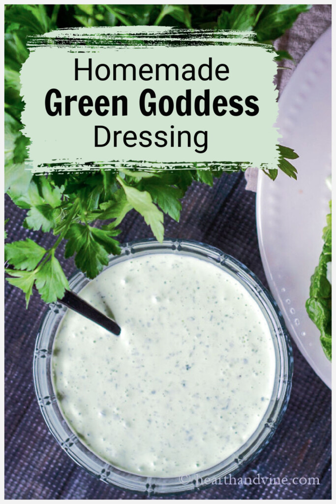 Aerial view of a bowl of green goddess salad dressing next to fresh parsley.