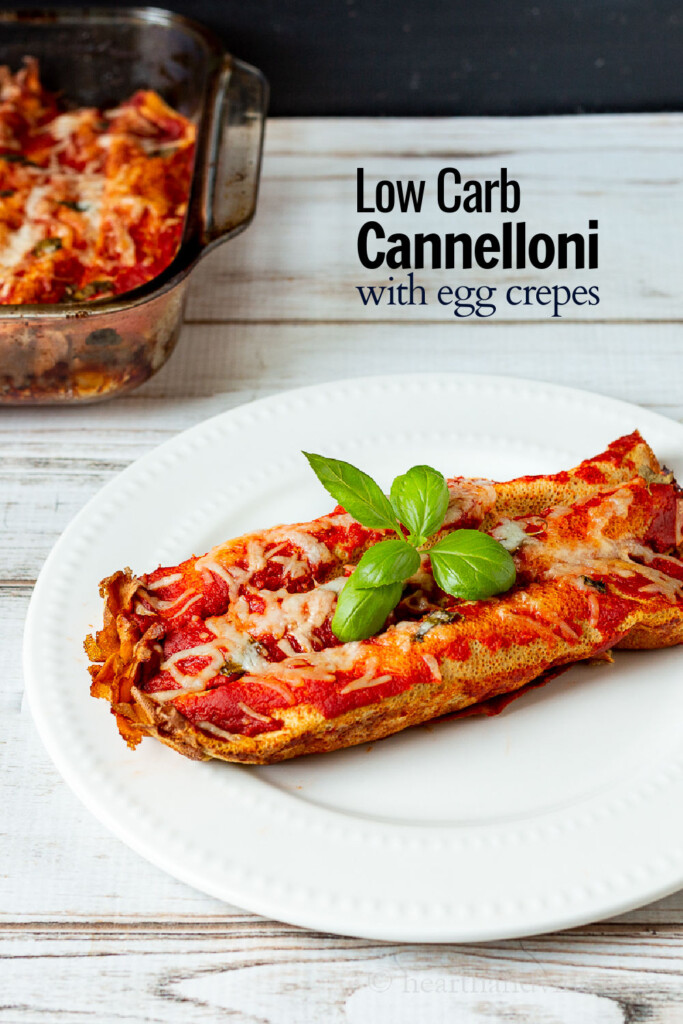 Plate of three cannelloni with a sprig of basil next to part of the pan they were cooked in.