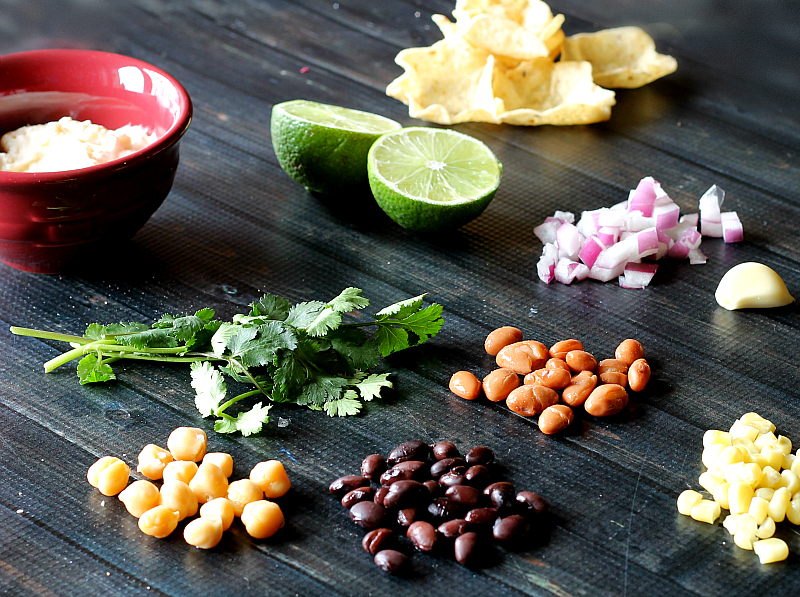 Chick peas, black beans, corn, pinto beans, red onions, cilantro, garlic, limes, tortilla scoops and dressing.