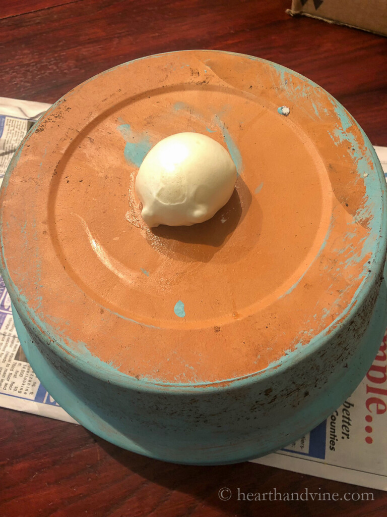 Bottom of clay pot with foam sealant sprayed into the drainage hole.