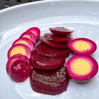 Sliced red pickled beet eggs and beets