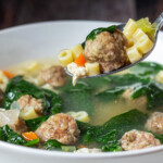 Italian wedding soup with a soup full coming out.