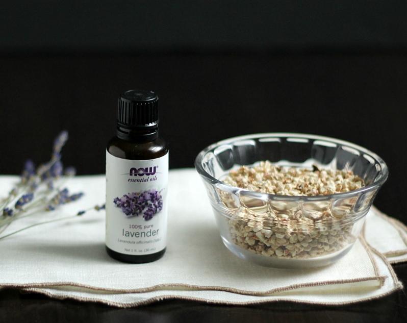 Bottle of lavender essential oil and a bowl of cellouse fiber.