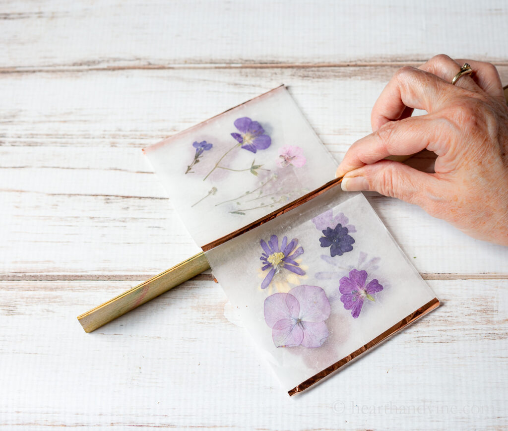 A ruler under the copper tape to help make a crease on the pressed flower wax paper sections.