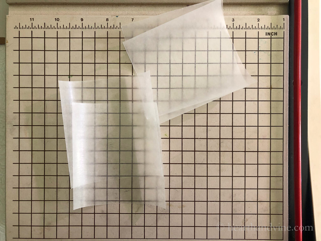 Square sheets of wax paper on a paper cutter.