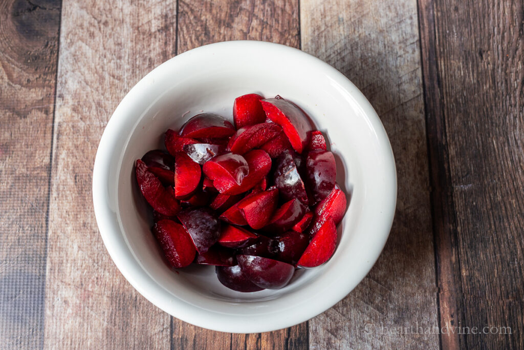 Bowl of fresh plums, pitted and cut into wedges.