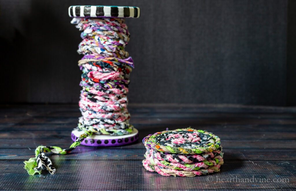 Spool of fabric twine next to a stack of fabric coasters.