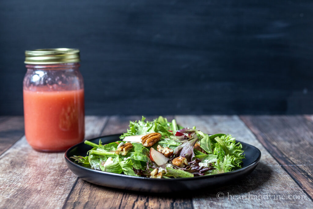 Pear gorgonzola salad with plum vinaigrette mason jar on the side.