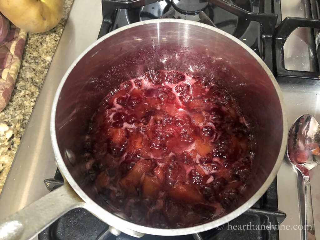 Plums and water reducing on the stove.