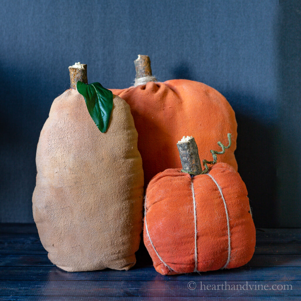 Three primitive fabric pumpkins on a table.