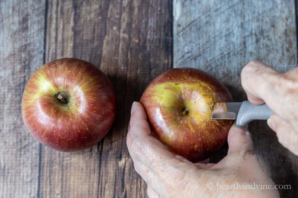 Cutting the top of an apple with a paring knife.