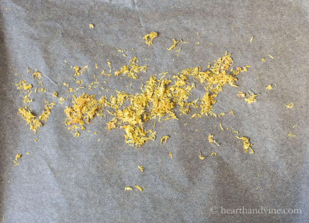 Dried lemon zest on parchment on a baking sheet.