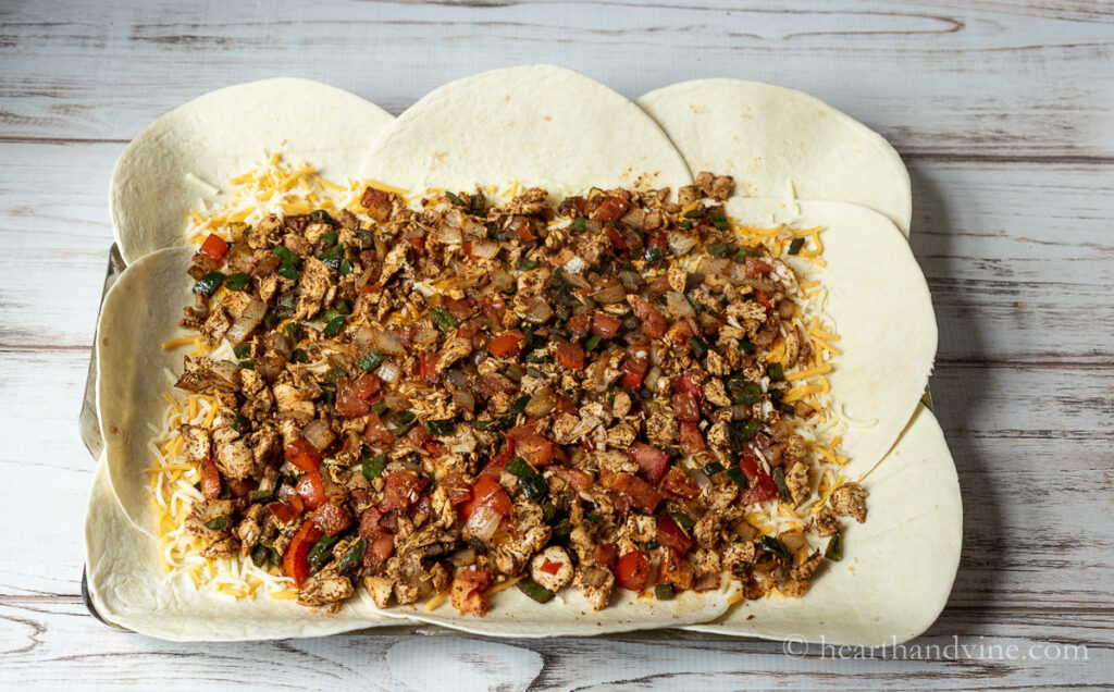 Chicken and vegetable mixture over the cheese and tortillas.