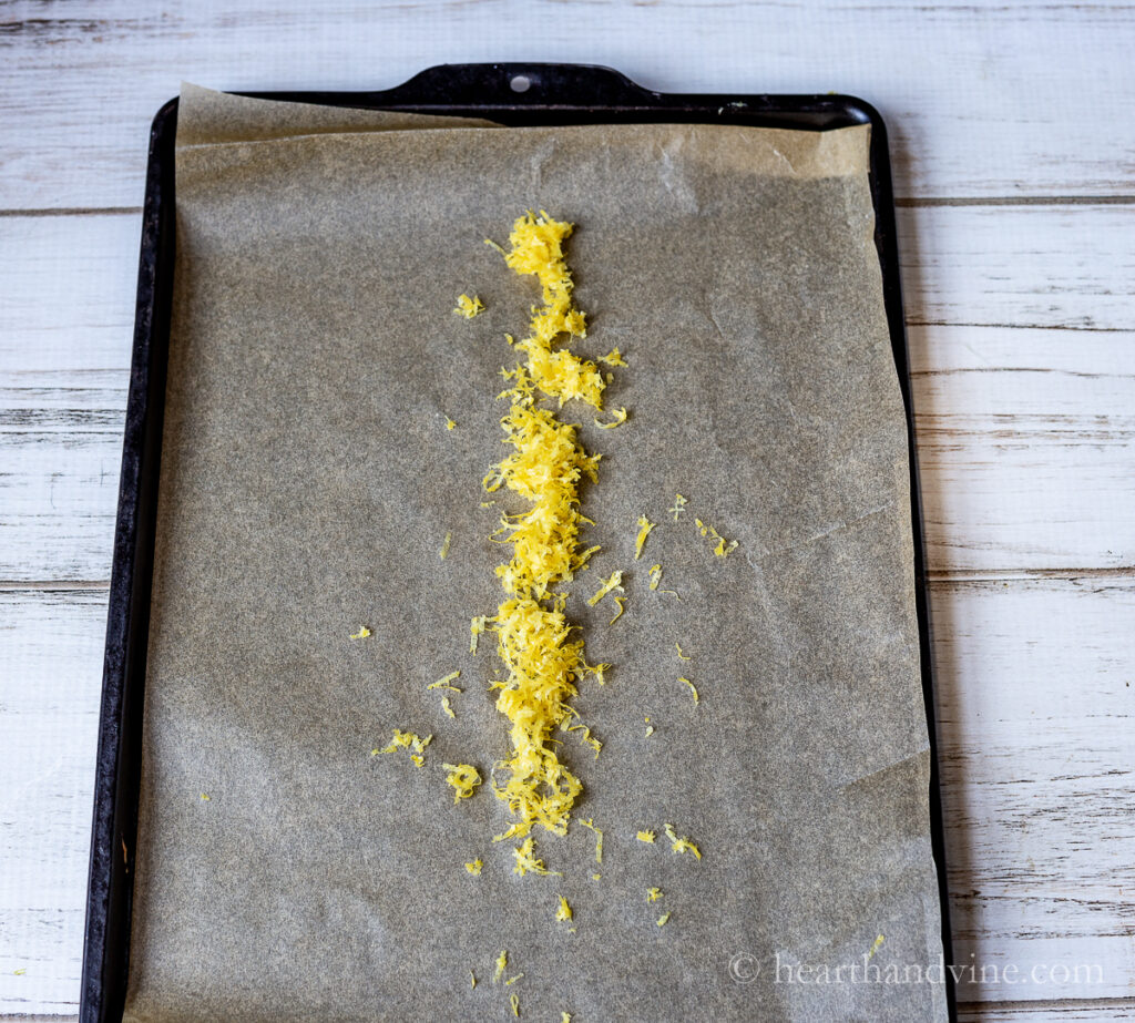 Lemon zest on parchment on a baking sheet.