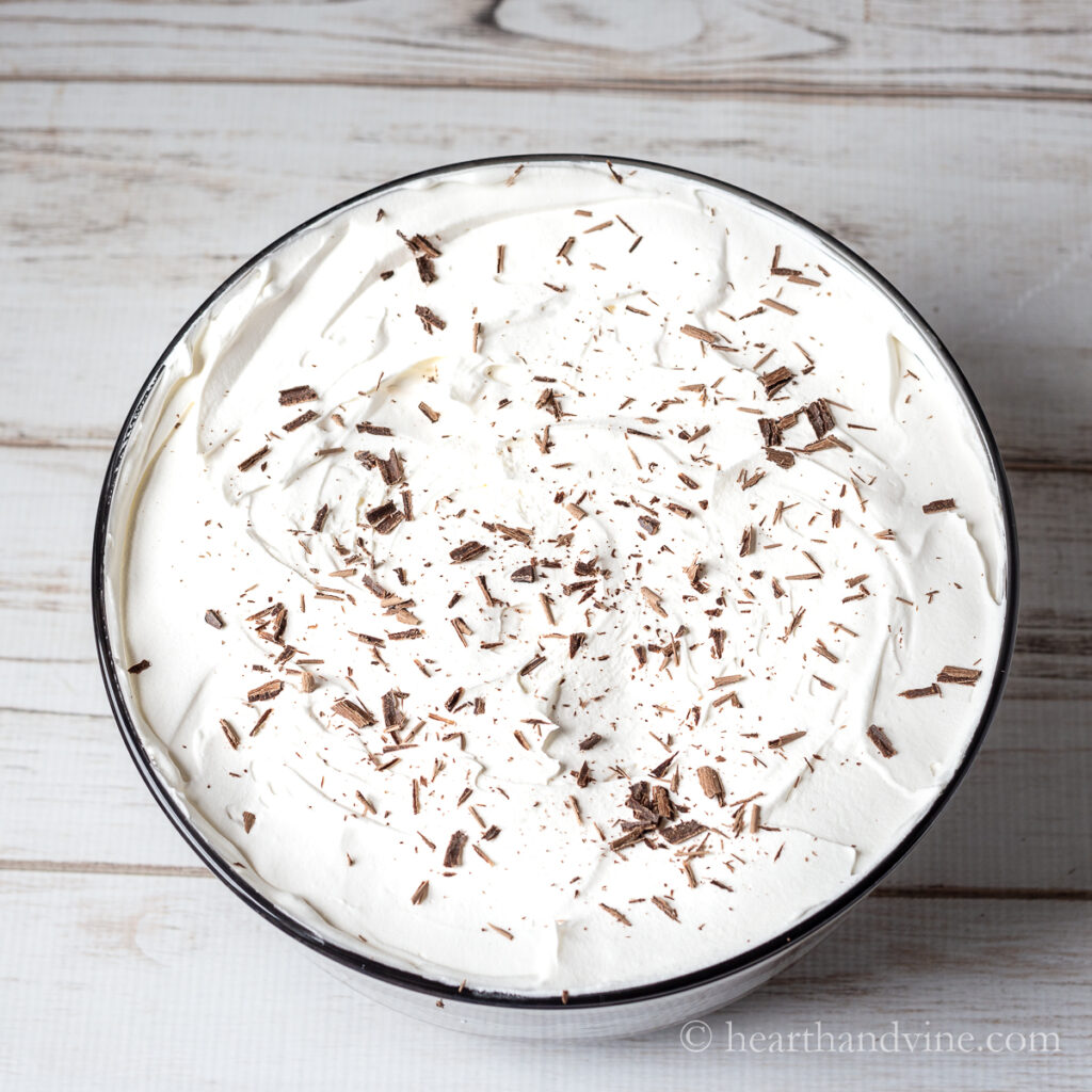 Top of chocolate pudding trifle with whipped cream and chocolate shavings.