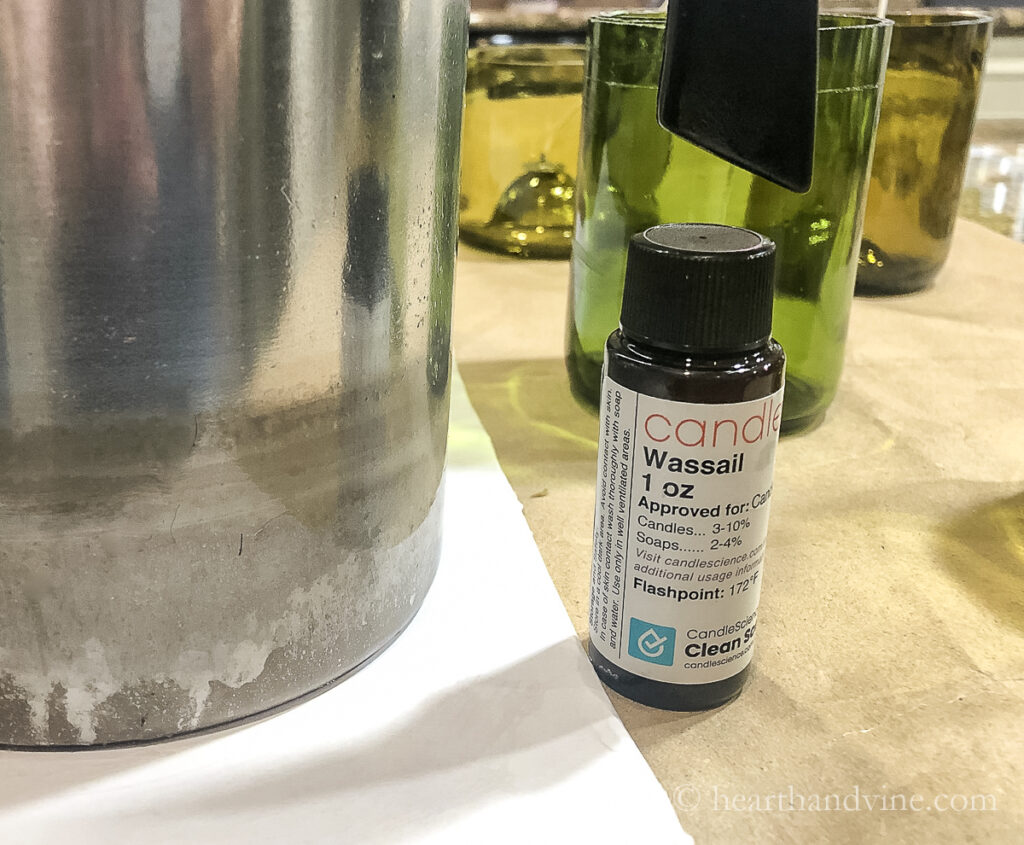 Bottle of fragrance oil 1 oz Wassail next to a wax pitcher.