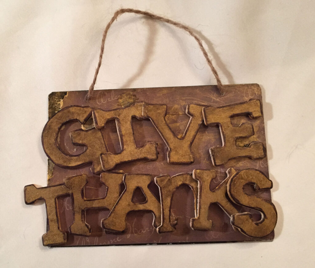 Metal sign that says Give Thanks.