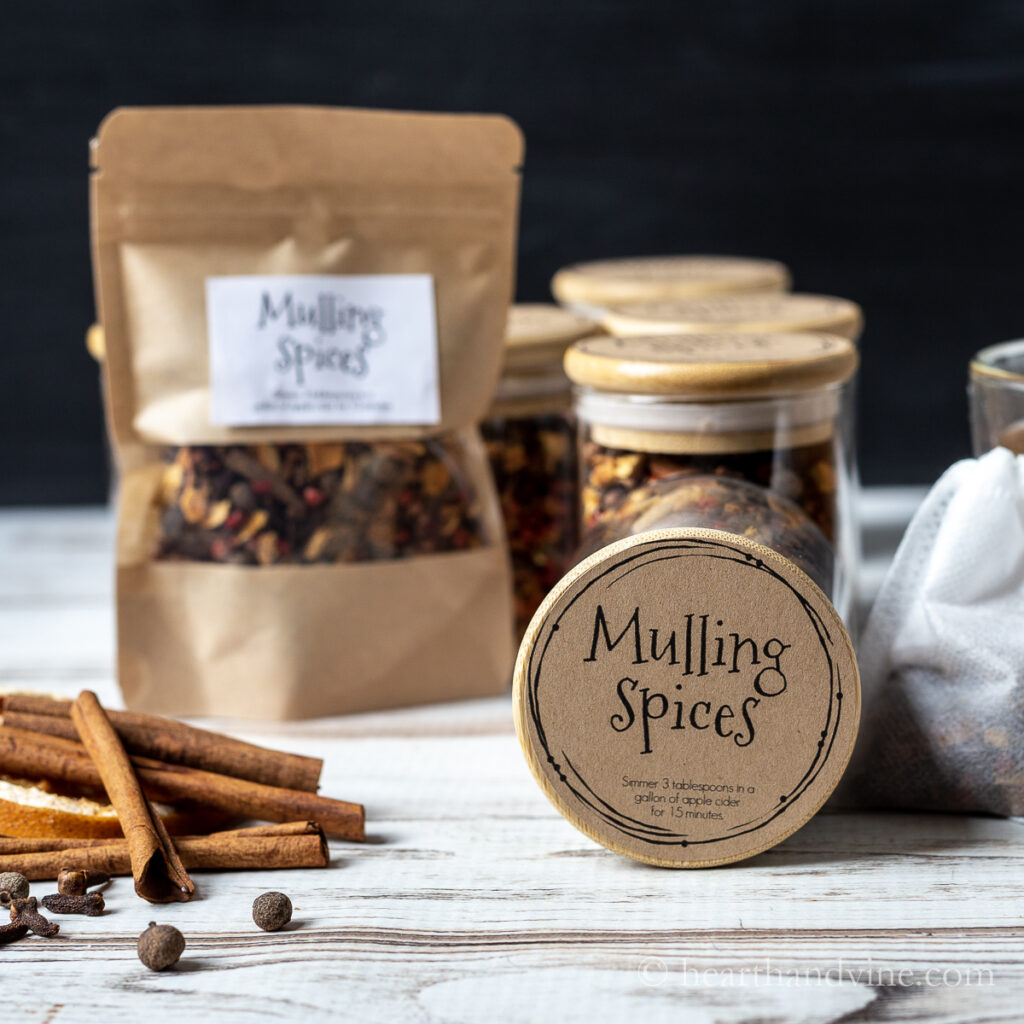 Jars and bags of mulling spices. Cinnamon sticks, cloves and allspice berries.