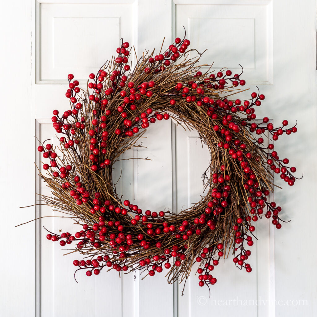 Red berry wreath on white door.
