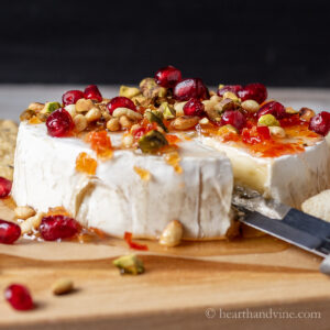 Baked brie with jam, pine nuts, pistachios, and pomegranate seeds.