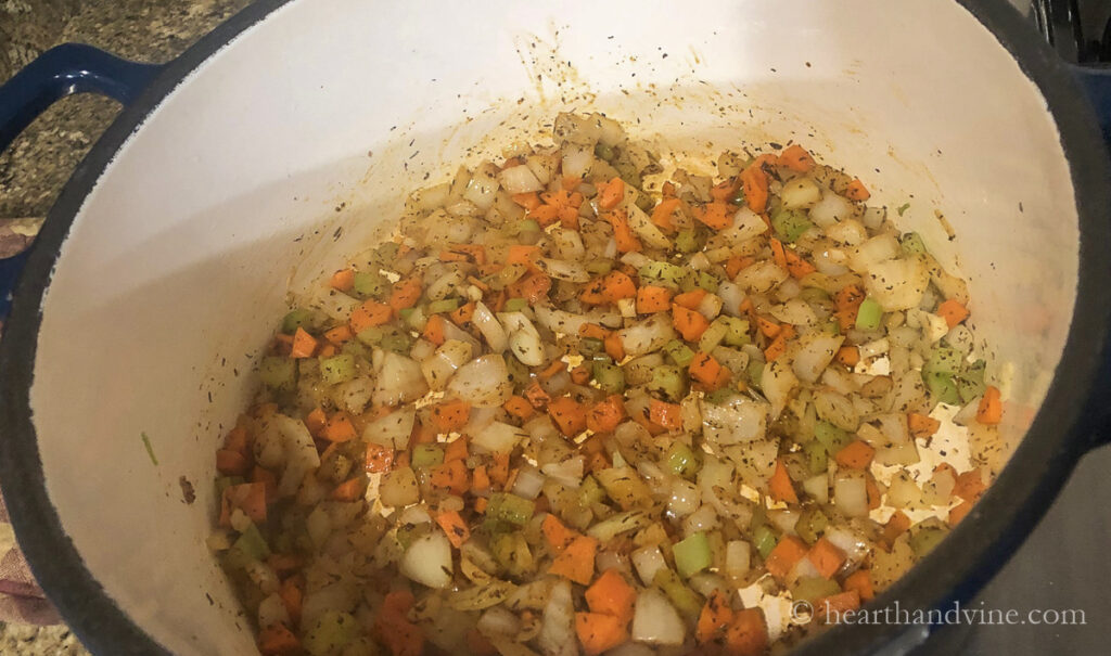 Sautéed celery, carrots, onion and spices in a heavy pot on the stove.