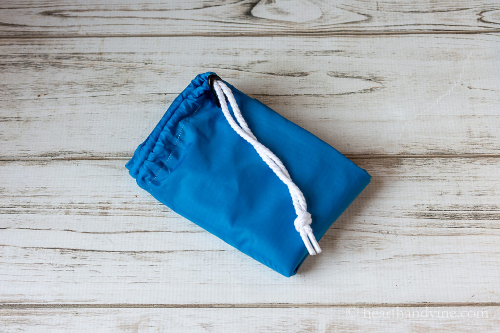 Nylon blue laundry bag folded up into a very small size.
