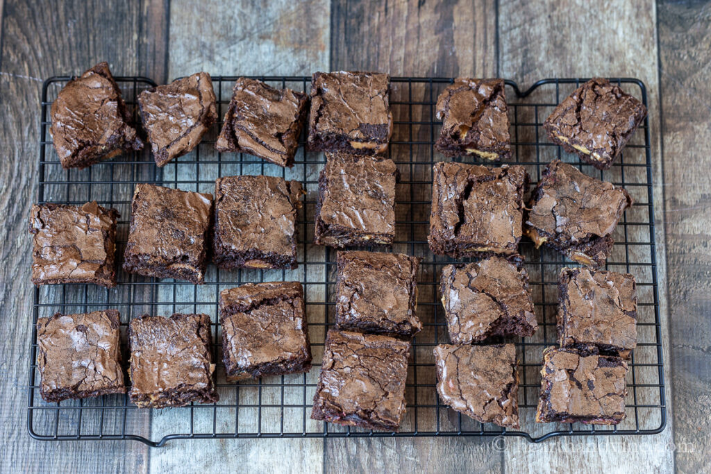 Baked brownies cut on a cooling tray.