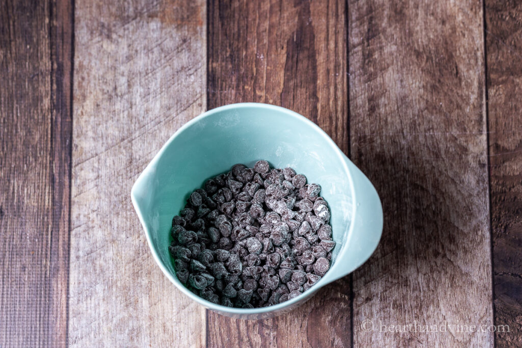 Chocolate chips dusted with flour in a mixing bowl.
