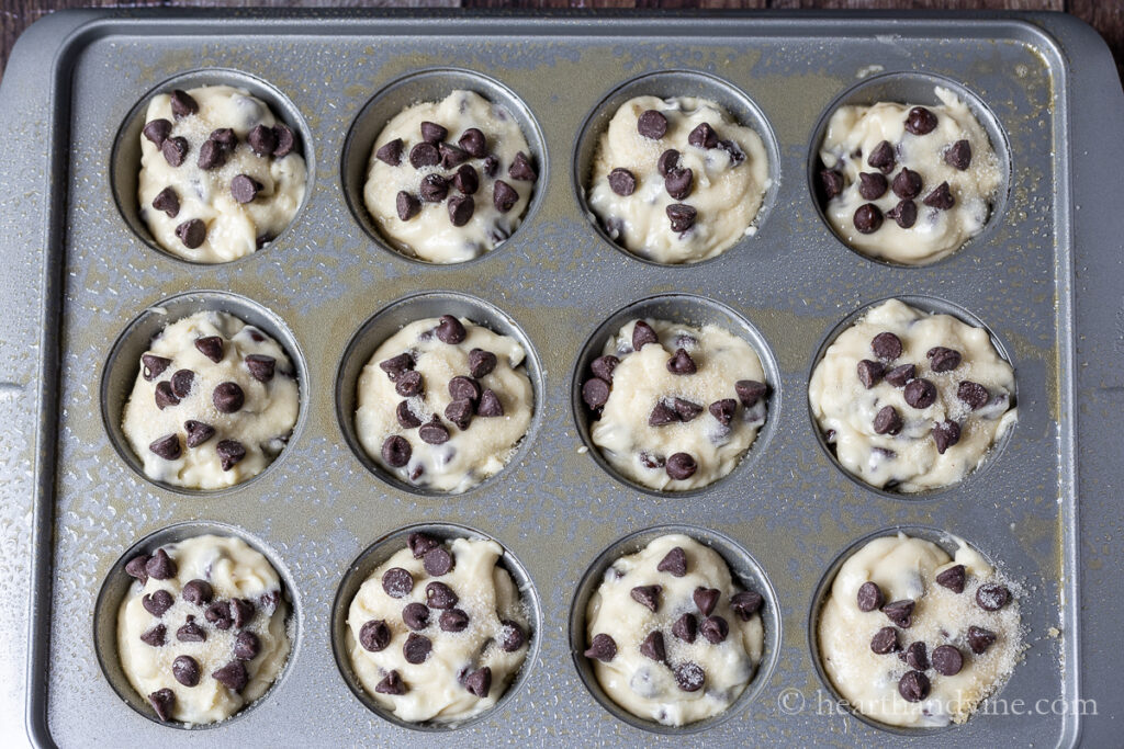 Chocolate chip muffin batter in a muffin baking tray.
