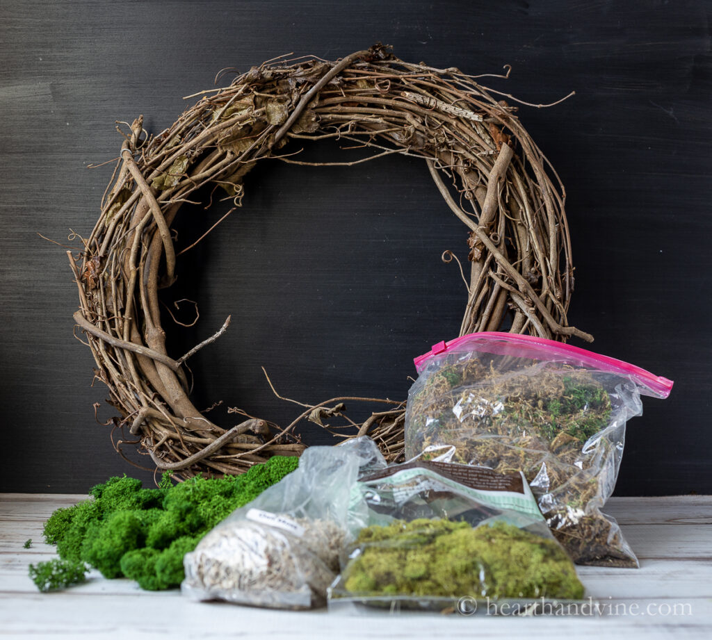 DIY moss wreath supplies including a grapevine wreath, and different shades of reindeer moss, oakmoss and sheet moss.