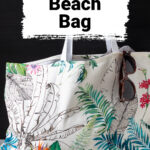 Tropical print beach bag with sunglasses hanging on the edge.