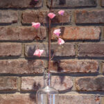 Tissue paper cherry blossom branch in a glass bottle.